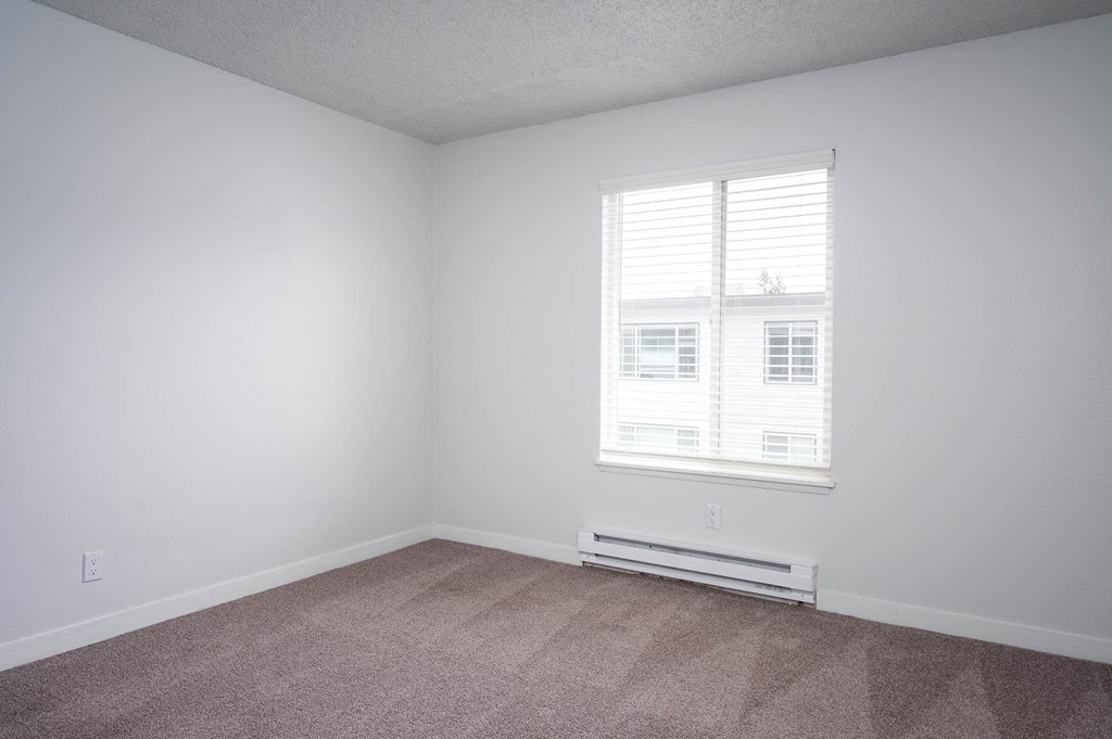 an empty room with white walls and a window